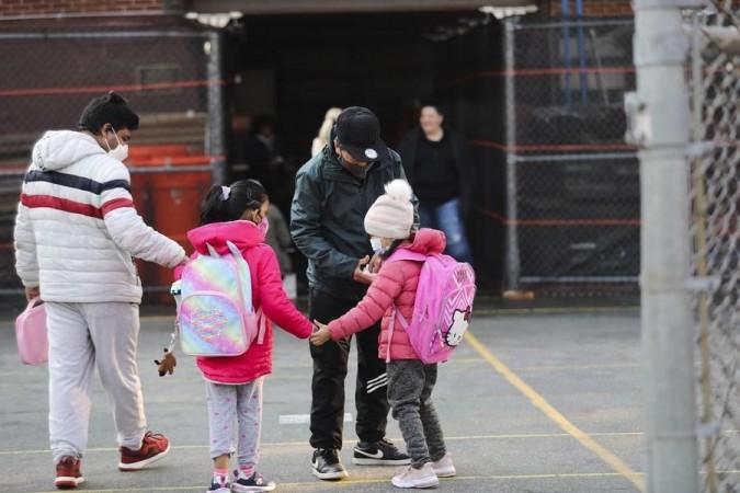 (File photo) Children greet each other as they arrive at school in New York, the United States, March 7, 2022