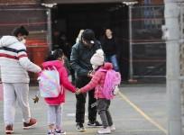 Children greet each other as they arrive at school in New York, the United States, March 7, 2022