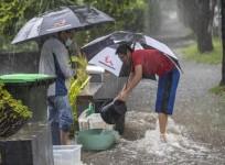 People stack baskets for flood control in Willoughby, New South Wales, Australia