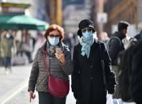 People wearing face masks walk on a street in Rome, Italy,