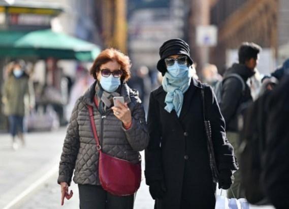 People wearing face masks walk on a street in Rome, Italy, People wearing face masks walk on a street in Rome, Italy,