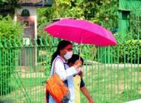 A woman uses an umbrella to protect from heat during a hot summer day in New Delhi on Sunday, Apr. 24, 2022