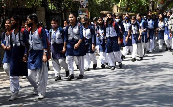 School students are on their way home after school in New Delhi on April 1, 2022.