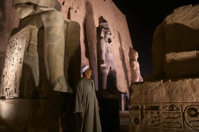 A man stands near a newly restored colossus statue of king Ramses II (C) at the Luxor Temple in Luxor, Egypt on April 18, 2017. Egypt's Ministry of Antiquities has conducted a comprehensive restoration work on a colossus statue of king Ramses II that once decorated the facade of the first pylon of the Luxor Temple. During the fourth century AD, the colossus was damaged by a destructive earthquake sarcophagus