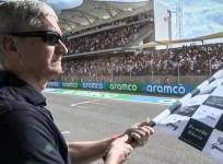 Apple CEO Tim Cook waves checkered flag at Formula 1 Grand Prix.