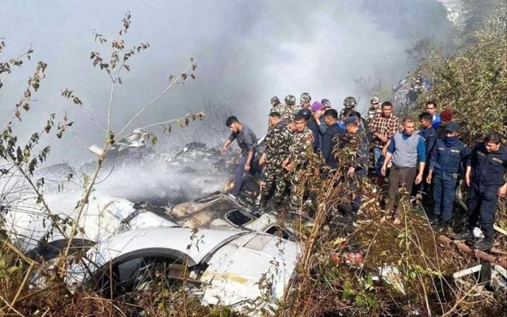 Locals watch the wreckage of a passenger plane in Pokhara, Nepal, Sunday, Jan.15, 2023. A passenger plane with 72 people on board crashed near Pokhara International Airport in Nepal.. Nepal