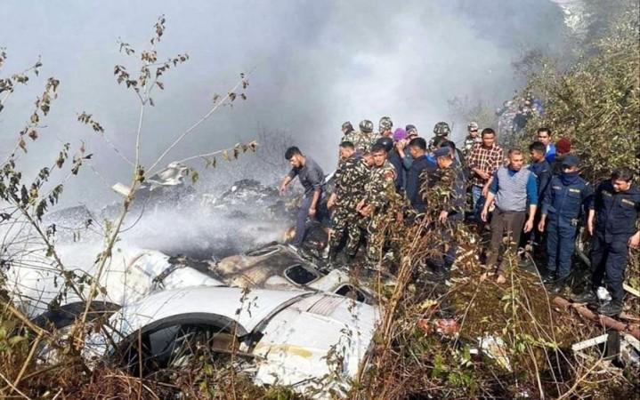 Locals watch the wreckage of a passenger plane in Pokhara, Nepal, Sunday, Jan.15, 2023. A passenger plane with 72 people on board crashed near Pokhara International Airport in Nepal.