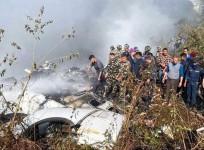 Locals watch the wreckage of a passenger plane in Pokhara, Nepal, Sunday, Jan.15, 2023. A passenger plane with 72 people on board crashed near Pokhara International Airport in Nepal.