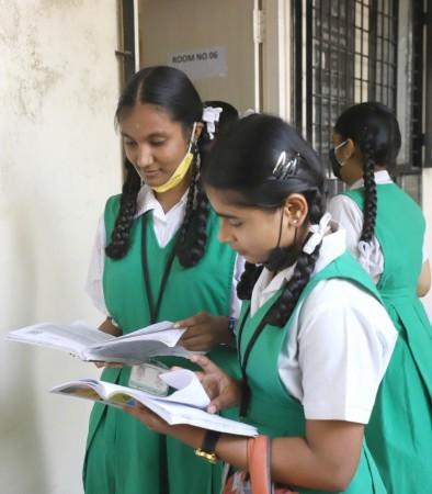 Students take last minute preparation before going to the SSLC examination Centre, Karnataka government is conducting the SSLC exams in the state from March 28,in Bengaluru on Monday 2022.(PHOTO:IANS) Students take last minute preparation before going to the SSLC examination Centre.