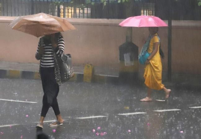 Bengaluru: Commuters hold umbrellas as they cross the road during heavy rain, in Bengaluru : Bengaluru: Commuters hold umbrellas as they cross the road during heavy rain, in Bengaluru, on Tuesday, June 20, 2023