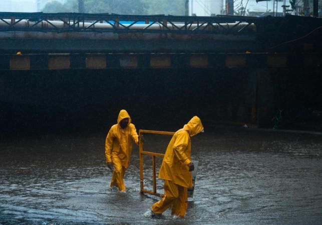 Mumbai: BMC workers are seen moving barricades on a waterlogged road amid heavy rainfall near Andheri subway in Mumbai on Wednesday, July 26, 2023. (Photo: IANS) Mumbai rains