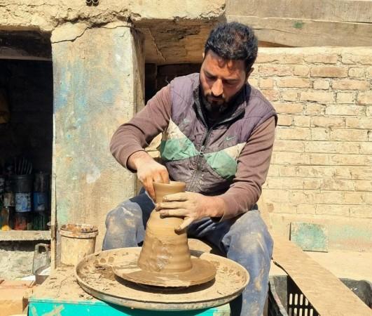 Mohammad Umar Kumar crafts a clay vessel, preserving Kashmir's centuries-old pottery tradition. From Commerce Graduate to Cultural Custodian, Kashmiri Artisan Restores Traditional Glazed Pottery.