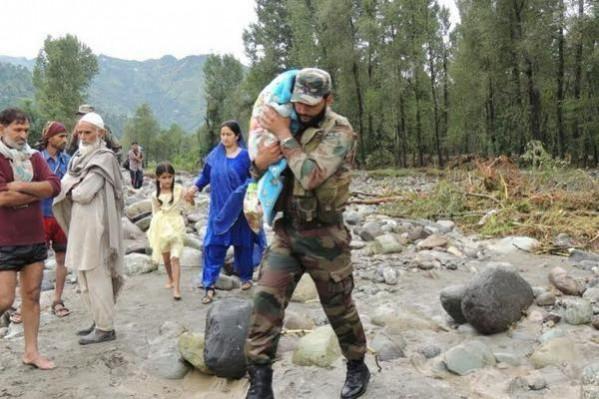 A soldier of the Army carrying a child rescued after cloudburst Rescue operation