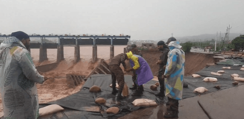 Amid heavy downpours, soldiers of the Army repairing damaged bridge on river Tawi Solder