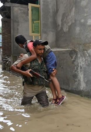 A cop of J&K Police evacuating a child in Srinagar Rescue operation
