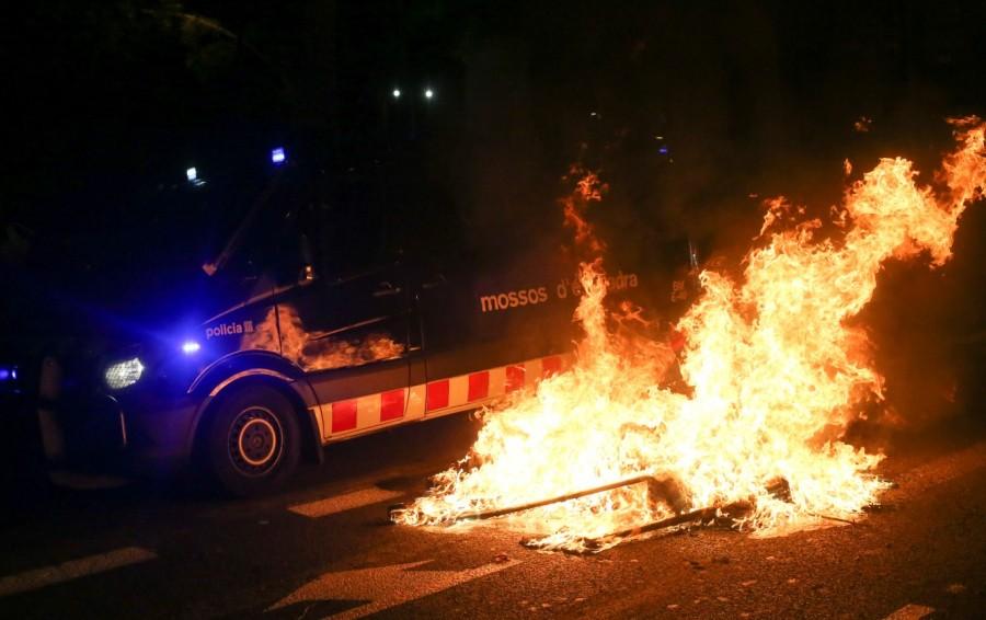 A police van passes a burning barricade outside the Catalonian parliament Catalan referendum anniversary,Riot police,Catalonia regional parliament,Barcelona,demonstration,Catalan anniversary
