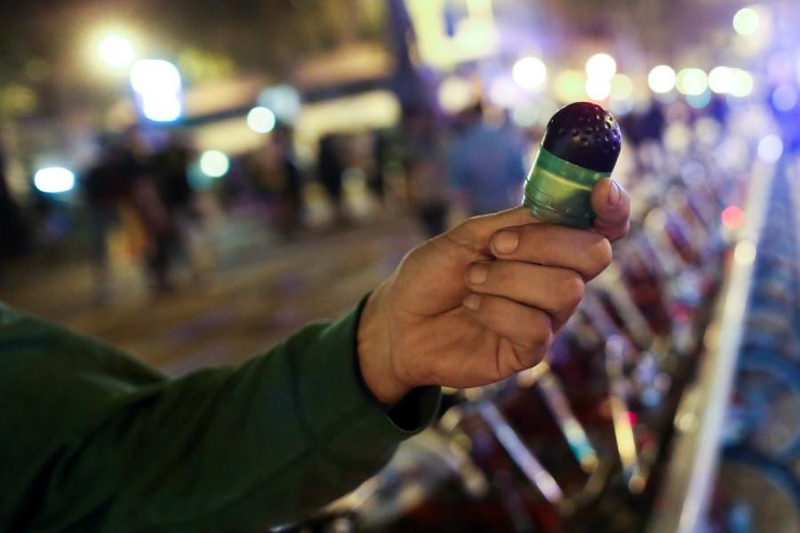 A projectile fired by police is held up after scuffles between protestors and police Catalan referendum anniversary,Riot police,Catalonia regional parliament,Barcelona,demonstration,Catalan anniversary