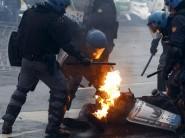 Policemen help their colleague caught on fire after being hit by a molotov bomb during a rally against Expo 2015 in Milan