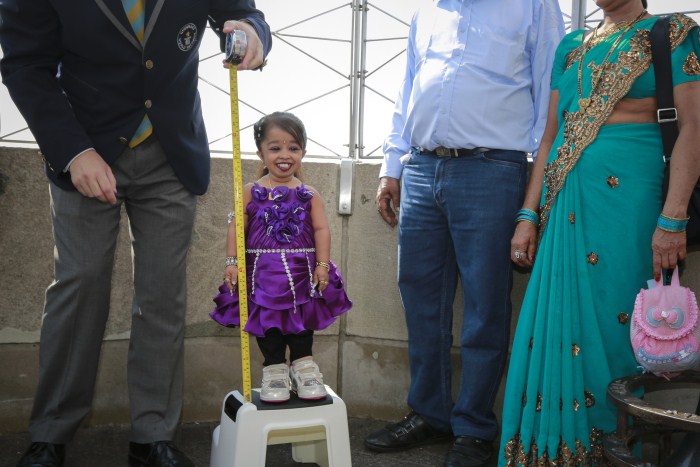 Jyoti Amge,19, from Nagpur, India, is measured by a Guinness World Record official on top of the Empire State Building in New York Weird World Records,World Records,Guinness record,Guinness record 2014,Guinness record 2015,world records list,world records 2013,world records human body,amazing world records,world records dance,easy world records to break