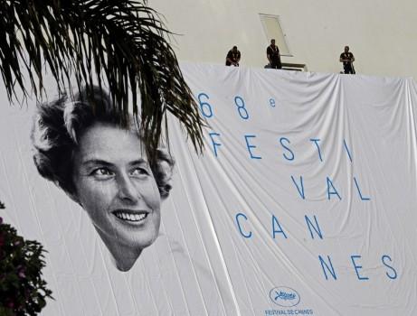 Workers set up a giant canvas of the official poster of the 68th Cannes Film Festival, featuring late actress Ingrid Bergman, on the Festival Palace in Cannes