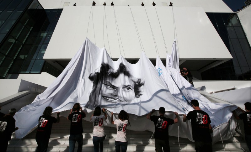 Workers set up a giant canvas of the official poster of the 68th Cannes Film Festival, featuring late actress Ingrid Bergman, on the Festival Palace in Cannes Gearing Up for Cannes Film Festival 2015,68th Cannes Film Festival 2015,Cannes Film Festival 2015,French Riviera town,Cannes Film Festival pics,Cannes Film Festival images,Cannes Film Festival,2015 Cannes Film Festival,Festival de Cannes 2015,cannes film