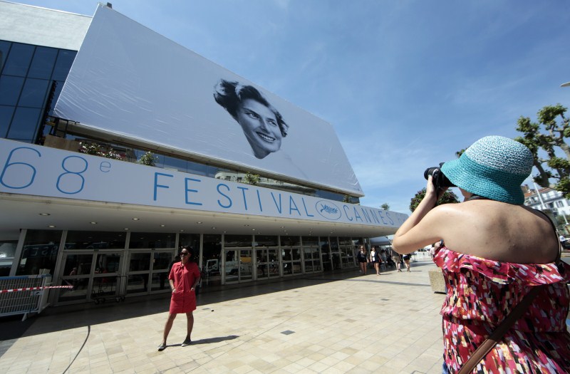 A woman takes pictures of a giant canvas of the official poster of the 68th Cannes Film Festival, featuring late actress Ingrid Bergman, on the Festival Palace in Cannes Gearing Up for Cannes Film Festival 2015,68th Cannes Film Festival 2015,Cannes Film Festival 2015,French Riviera town,Cannes Film Festival pics,Cannes Film Festival images,Cannes Film Festival,2015 Cannes Film Festival,Festival de Cannes 2015,cannes film
