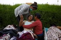An earthquake victim reacts in pain after being moved out from the hospital to the open ground for treatment, in Kathmandu