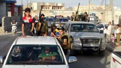 Tribal fighters and Iraqi security forces take part in a parade down a street in the city of Ramadi