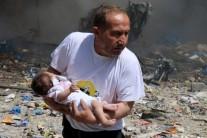 A man holds a baby that survived what activists said was a site hit by a barrel bomb dropped by forces loyal to Syrian President Bashar al-Assad at the old city of Aleppo