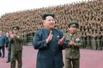 North Korean leader Kim Jong Un (C) applauds during a photo session with the soldier-builders
