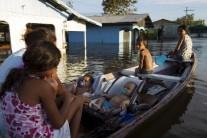 Residents are pictured in their canoe in a street flooded by the rising Rio Solimoes, one of the two main branches of the Amazon River, in Anama, Amazonas state, Brazil