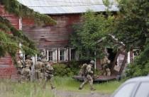 Police officers search a property near the Clinton Correctional Facility in Dannemora, New York