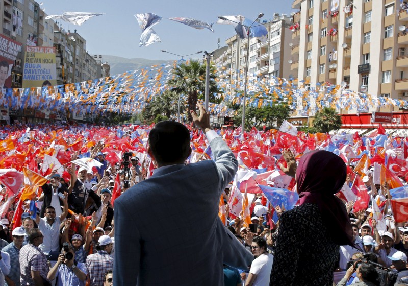 Turkish Prime Minister Ahmet Davutoglu (L), accompanied by his wife Sare Davutoglu, greets AK Party supporters during an election rally Turkey Faces a New Political Reality,Turkey New Political Reality,New Political Reality,Tayyip Erdogan,AK Party,Erdogan,Supporters of Turkey's,Turkey,Prime Minister Ahmet Davutoglu,Ahmet Davutoglu
