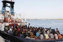 Migrants wait to disembark in the Sicilian harbour of Augusta, Italy