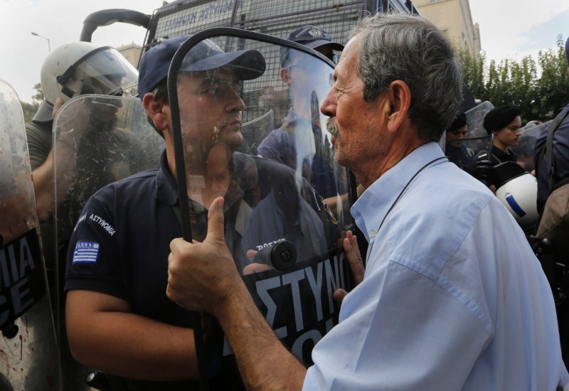 A pensioner pushes riot policemen during scuffles between protesting pensioners Greece's Pension Problem,Greece Pension Problem,Pension Problem,Greek Pension System,European Pensions,Greece's generous pensions,Greece's Pension System