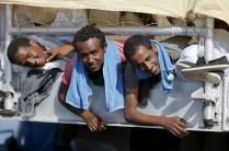 Migrants wait to disembark from the expedition vessel Phoenix in the Sicilian harbour of Augusta
