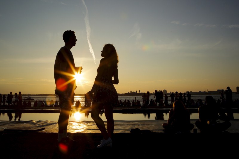 People enjoy a sunny afternoon during the solstice day at Governors Island in New York Couple kiss,Couple kiss during the solstice day at Governors Island,solstice day at Governors Island,Governors Island,solstice day,Couple kisses during the Solstice day at Governors Island