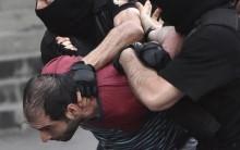 A demonstrator is detained by riot police during a rally against a recent decision to raise public electricity prices in Yerevan, Armenia