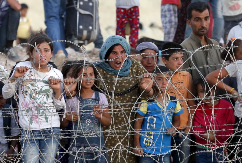 Syrian Kurds from Kobani wait behind the border fences to cross into Turkey ISIS Attacks,ISIS Attacks Kobani Again,Islamic State,ISIS militants,Syrian town,Islamic State attacks Kobani,Turkey,Sanliurfa province,Sanliurfa