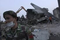 An Indonesian soldier stands near the tail section of a military C-130 transport plane which crashed