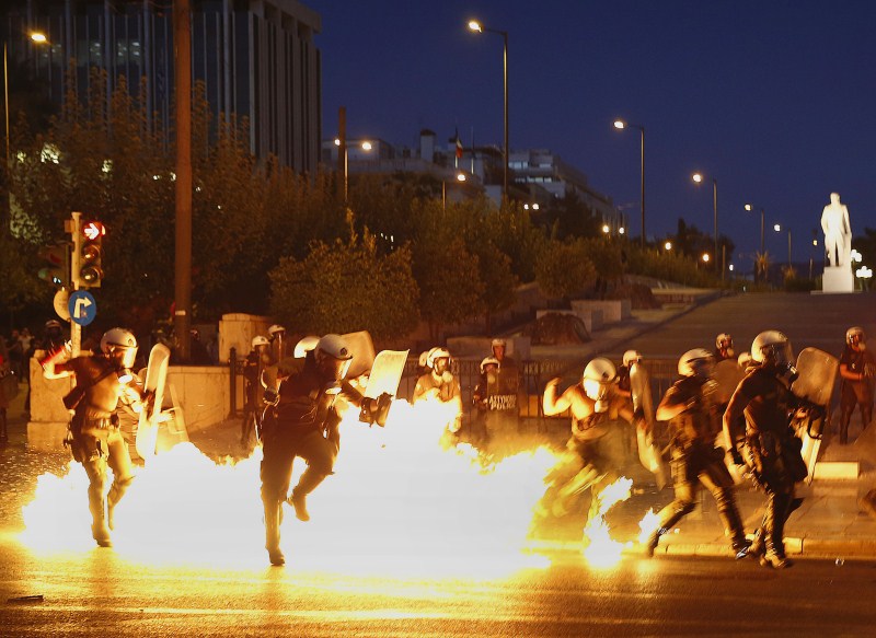 Riot policemen try to avoid an exploding petrol bomb during clashes in Athens Protests Turn Violent in Greece,Protests in Greece,Anti-austerity movement in Greece,Greece protests turn violent,bailout deal,amid protests,anti-establishment protesters
