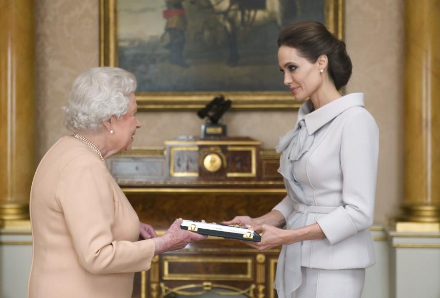 Angelina Jolie is presented with the Insignia of an Honorary Dame Grand Cross of the Most Distinguished Order of St Michael and St George, by Britain's Queen Elizabeth in the 1844 room at Buckingham Palace in London on 10 October 2014. Angelia jolie,angelia jolie photos,angelia jolie special moments,angelia jolie upcoming films