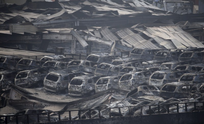 Damaged vehicles are seen at the site of explosions at the Binhai new district in Tianjin. Tianjin Blasts,New Cars Ruined,Ten thousands New Cars Ruined,Damaged cars,Cars Ruined in Tianjin Blasts