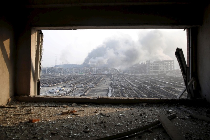 Damaged vehicles are seen at the site of explosions at the Binhai new district in Tianjin. Tianjin Blasts,New Cars Ruined,Ten thousands New Cars Ruined,Damaged cars,Cars Ruined in Tianjin Blasts