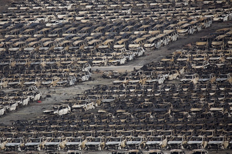Damaged vehicles are seen at the site of explosions at the Binhai new district in Tianjin. Tianjin Blasts,New Cars Ruined,Ten thousands New Cars Ruined,Damaged cars,Cars Ruined in Tianjin Blasts