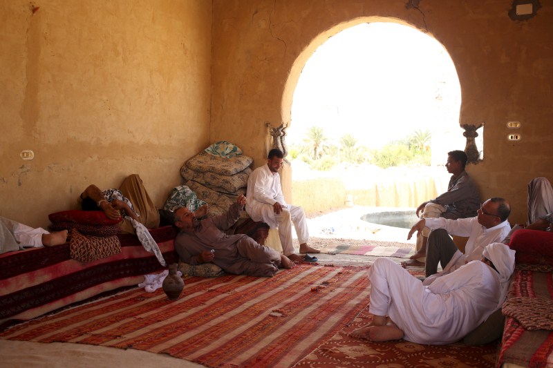 Patients relax in the shade before treatment, which includes massages by the feet of health workers who also submerge their patients up to their neck in the desert. Patients drink mint tea in tents following the treatment. Hot Sand Baths of Siwa,Hot Sand Baths,Patients Sand Baths of Siwa,desert,Patients,treatment,sand bath treatment,sand bath