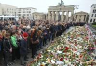 Photos of People observe a minute of silence in tribute to victims of Friday's attacks.