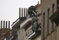 Belgian police surround houses as they search for suspects in connection with the attacks on Paris.