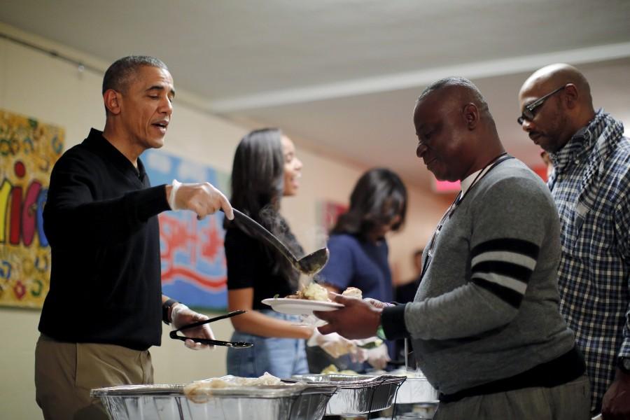 U.S. President Barack Obama, his daughter Malia and First Lady Michelle Obama serve thanksgiving dinner at Friendship Place Homeless Center at the St. Luke's Methodist church in Washington. Thanksgiving 2015,Thanksgiving day,Barack Obama,Malia Obama,Michelle Obama,thanksgiving dinner,Friendship Place Homeless Center