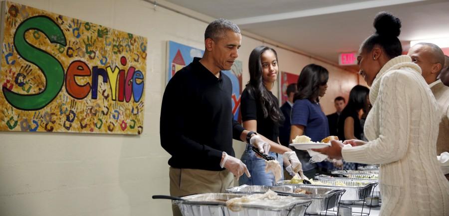 U.S. President Barack Obama, his daughter Malia and First Lady Michelle Obama serve thanksgiving dinner at Friendship Place Homeless Center at the St. Luke's Methodist church in Washington. Thanksgiving 2015,Thanksgiving day,Barack Obama,Malia Obama,Michelle Obama,thanksgiving dinner,Friendship Place Homeless Center